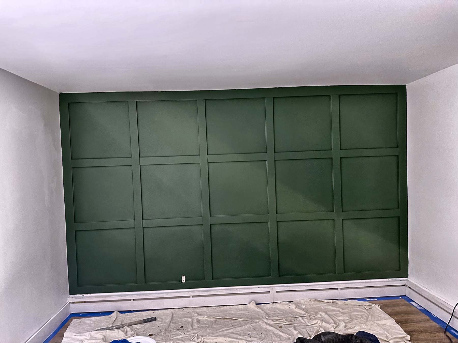 Custom board-and-batten accent wall in deep green, painted and finished by the Eron Renovations founder