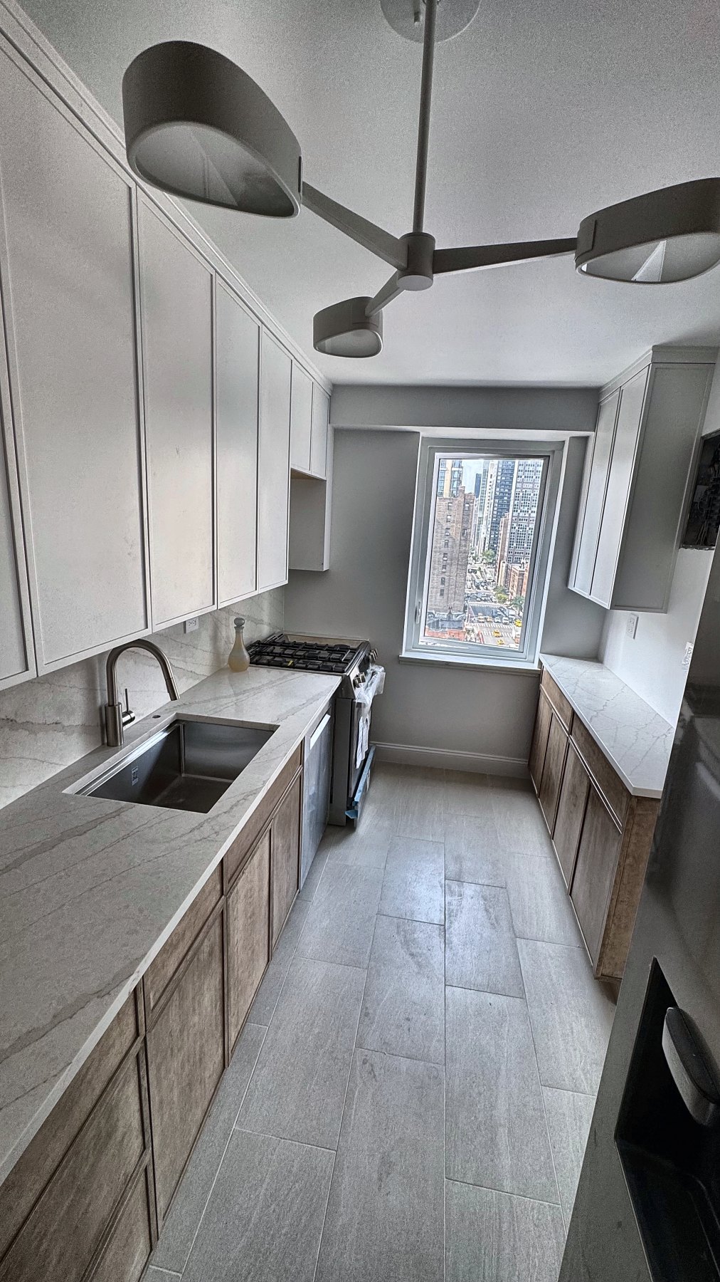 Completed kitchen renovation with two-tone cabinetry and quartz countertops — built by the Eron Renovations founder